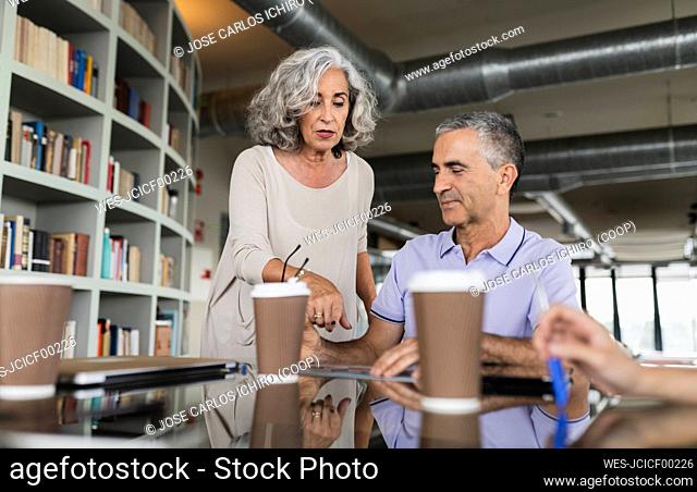 Senior businesswoman discussing with businessman in office