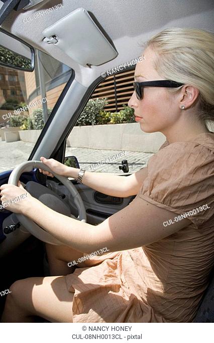 Young woman driving electric car