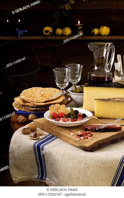 Rustic light meal from South Tyrol, consisting of dry-cured ham, Schüttelbrot (crispy unleavened bread), nuts, cheese and wine