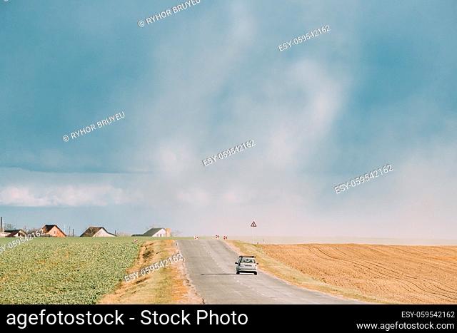 Belarus, Europe. Spring Dust Storm. A Dust Cloud From Agricultural Field Envelops Road Along Which Car Is Traveling