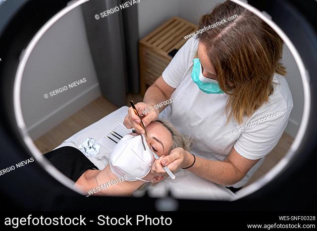 Female beautician giving beauty treatment to customer at spa