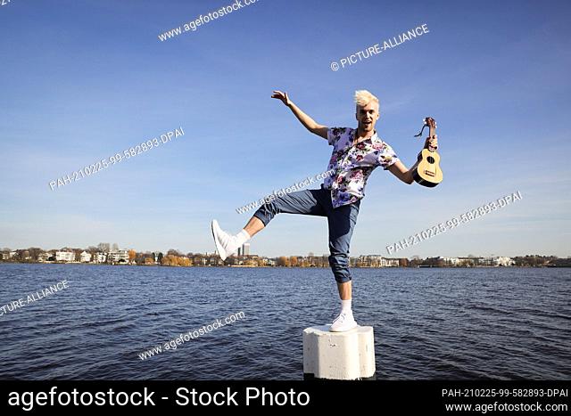 24 February 2021, Hamburg: Jendrik Sigwart, singer and musical performer, stands on a bollard during a photo session at the Alster