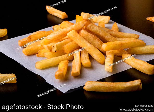 fresh yellow fries on a black table