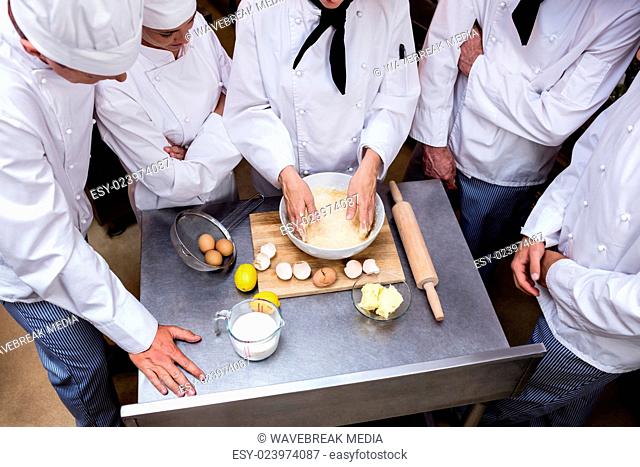 Head chef teaching his team to prepare a dough