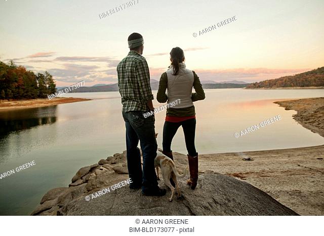 Couple and dog admiring remote lake