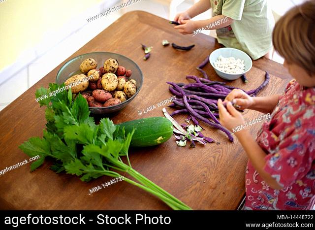 Father prepares fresh vegetables with children