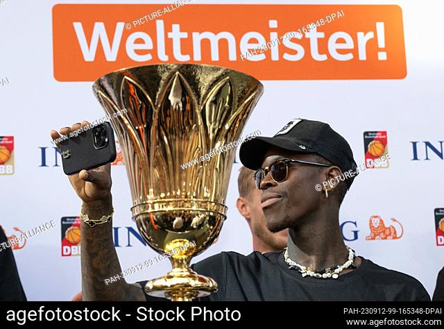 12 September 2023, Hesse, Frankfurt/Main: Dennis Schröder, captain of the national basketball team, stands next to the trophy at the team's reception in...