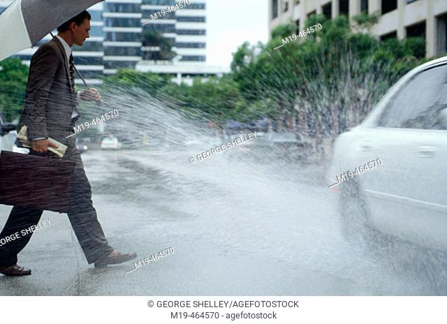 businessman gets splashed by a passing car