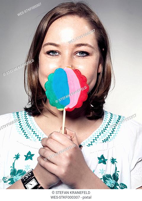 Portrait of Young woman holding lollipop, close up