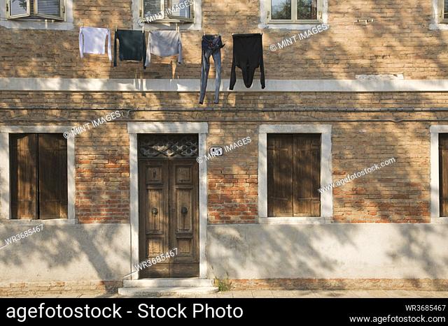 Washing line with laundry hanging on brick building exterior