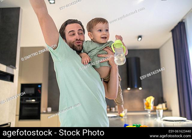 Baby-sitting. Young father spending time with his cute babyboy and looking happy