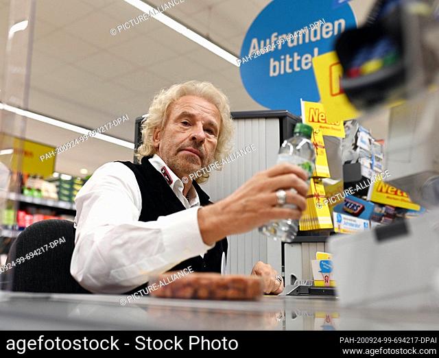 24 September 2020, Baden-Wuerttemberg, Rastatt: The entertainer Thomas Gottschalk sits as a volunteer cashier at the cash desk of a Netto Marken-Discount branch...