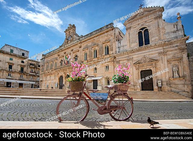 Old fashion bike with flower in front of Town hall (Palazzo Municipale) in the center of Ostuni, Apulia, Puglia, Italy