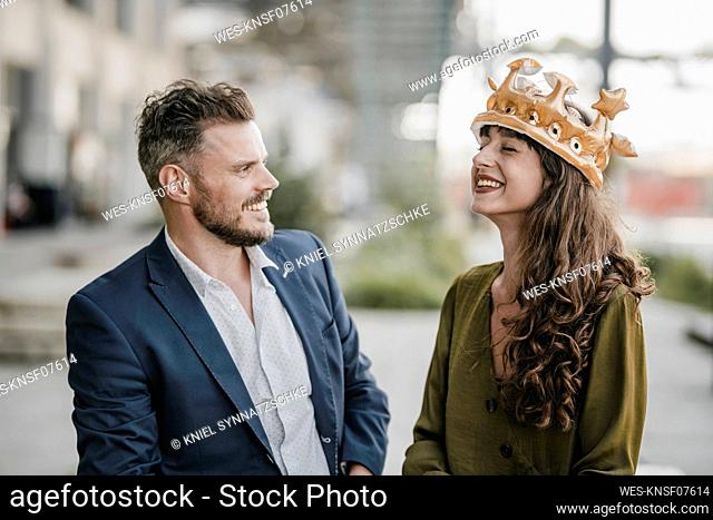 Smiling businessman looking at woman wearing a crown