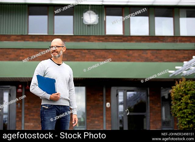 Teacher standing in front of school