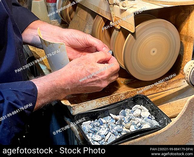 PRODUCTION - 04 May 2023, Australia, Sydney: Opal prospector Robert Oberdorfer cuts a small opal stone at the National Opal Collection