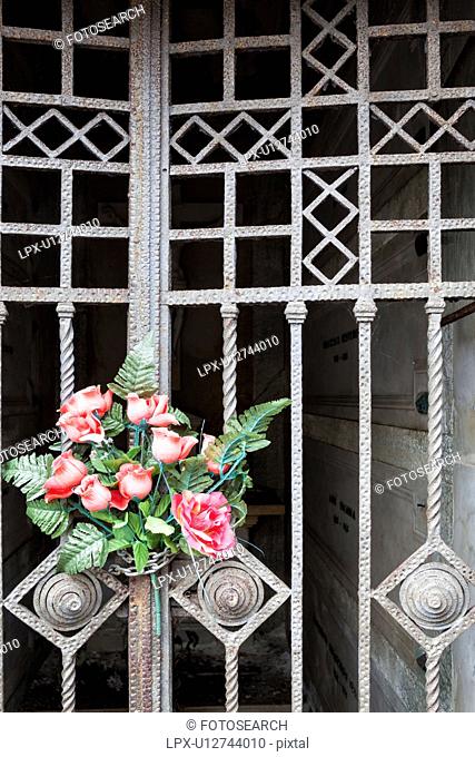 Red roses tied to metal wrought iron gate at cemetery, detail view, Monterosso al Mare, Cinque Terre, Liguria, Italy