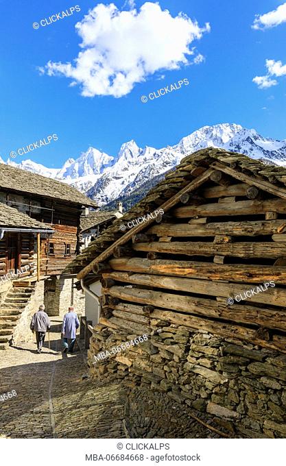 Elderly men between typical wood houses of Soglio Maloja canton of Graubunden Engadin Bregaglia Valley Switzerland Europe