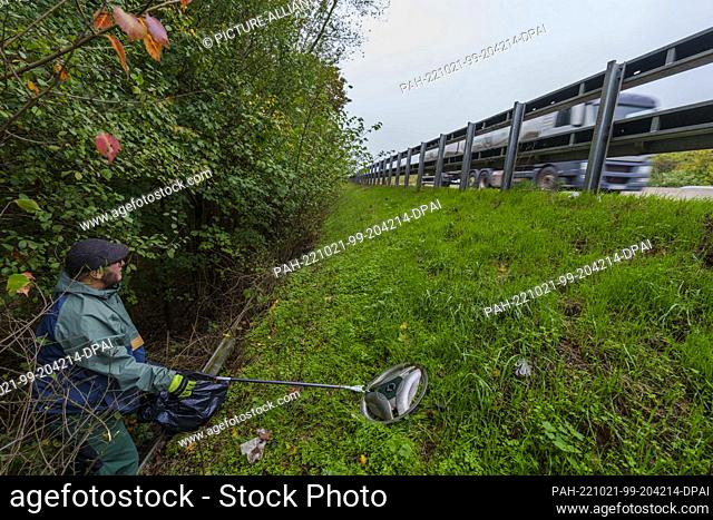 PRODUCTION - 14 October 2022, Hesse, Heusenstamm: Florian Früchel picks up a hubcap with his grapple, right next to the A3