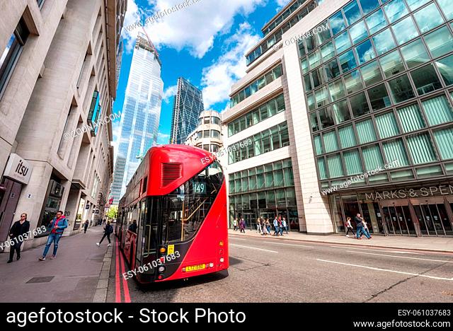 London, England - May 12, 2019: London's iconic red double-decker bus with awesome modern skyscrapers architecture in City