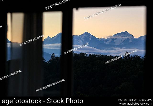 20 September 2023, Switzerland, Bern: A panorama of the three famous Swiss peaks Eiger (l-r), Mönch and Jungfrau can be seen from a window at sunrise