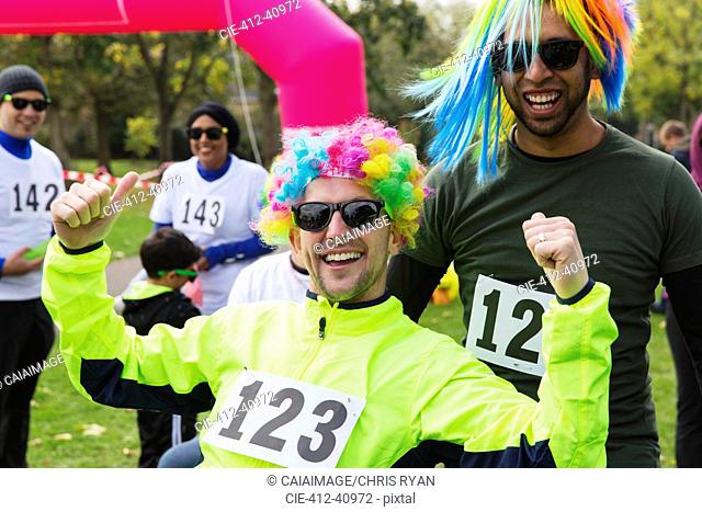 Portrait enthusiastic male runners wearing wigs at charity run