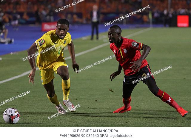 26 June 2019, Egypt, Cairo: Uganda's Godfrey Walusimbi (R) and Zimbabwe's Tendayi Darikwa battle for the ball during the 2019 Africa Cup of Nations Group A...