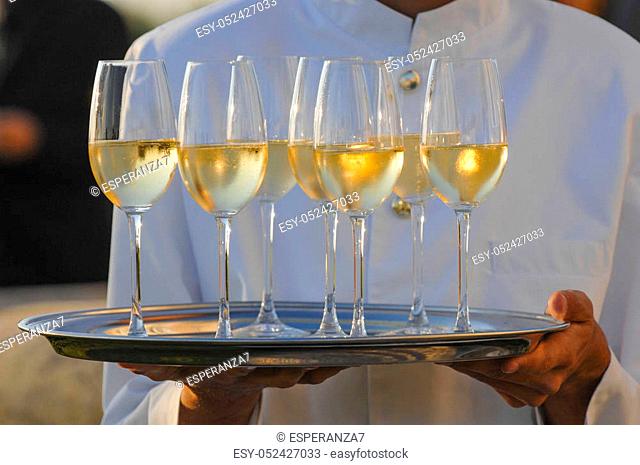 Professional male waiter in uniform serving champagne, Dri