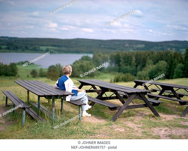 A senior woman admiring the view of Smaland, Sweden