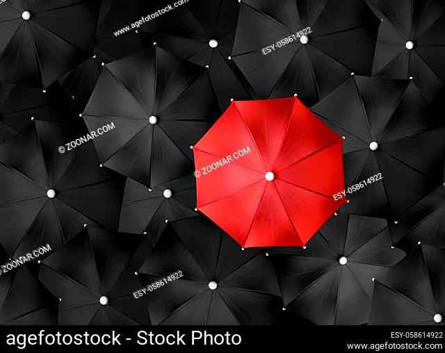 Concept image with lots of black umbrellas and a red umbrella that stands out, be unique