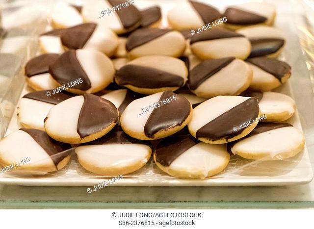 Chocolate and vanilla frosted butter cookies, displayed on a tray and offered for sale at an upscale New York City food court