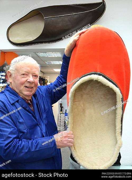27 September 2022, Saxony, Bad Dübender: Laughing, 87-year-old master shoemaker Horst Littmann stands in his shoe and leather goods store with an almost...