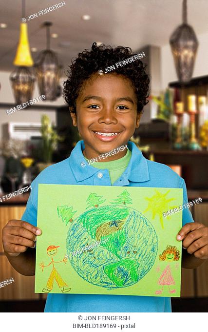 African boy holding drawing of the Earth