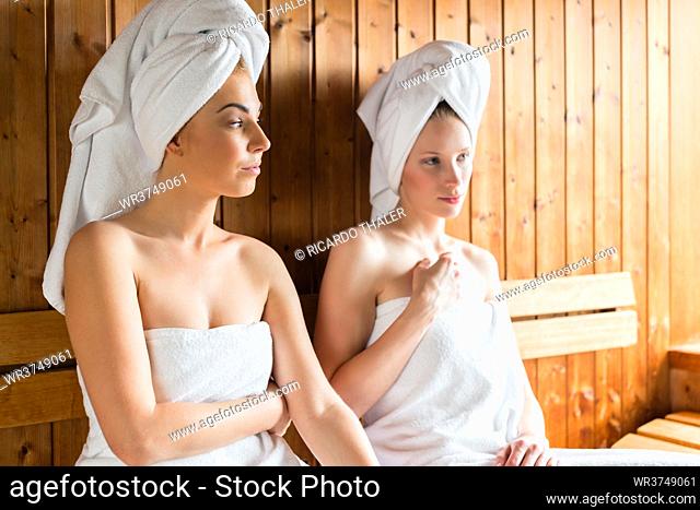 Two Women in wellness spa relaxing in wooden sauna