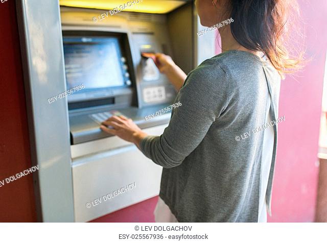 finance, money, bank and people concept - close up of woman inserting card to atm machine