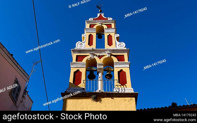 Greece, Greek Islands, Ionian Islands, Corfu, Corfu Town, old town, looking up at multi-storey bell tower, red and yellow, blue sky and cloudless
