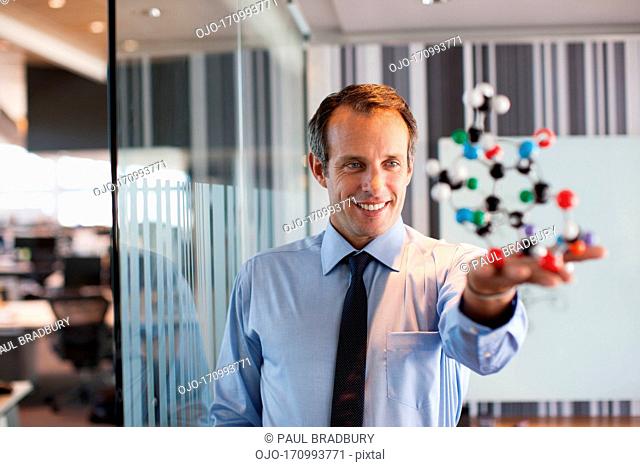 Businessman holding molecule model in office