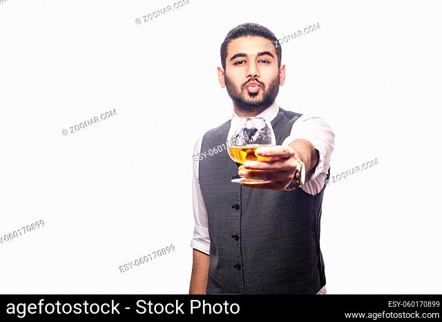 Handsome bearded businessman holding a glass of whiskey. share drink and send kiss. studio shot, isolated on white background