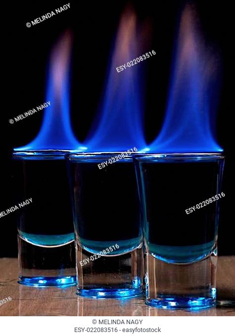 Burning drink in shot glass on a table