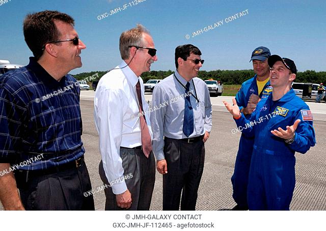 NASA astronaut Garrett Reisman (right) jokes with LeRoy Cain (left), NASA deputy shuttle program manager; Bill Gerstenmaier (second left)