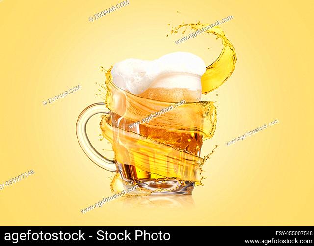 Creative flying spiral yellow splash aroung full glass mug of fresh cold light beer with thick foam on a light yellow background, copy space