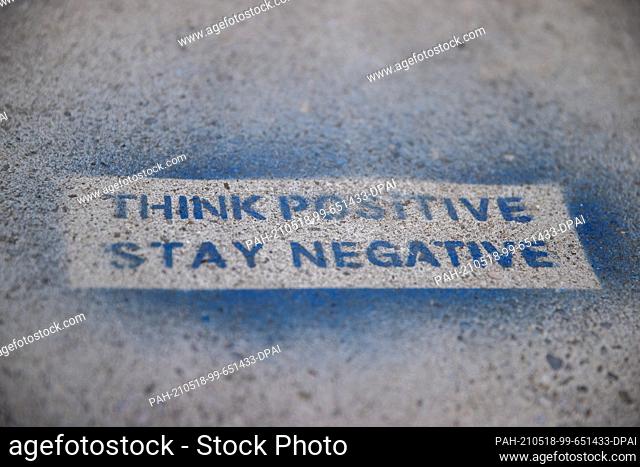 18 May 2021, Bavaria, Nuremberg: ""Think positive - Stay negative"" is spray-painted on a downtown stone. Photo: Daniel Karmann/dpa