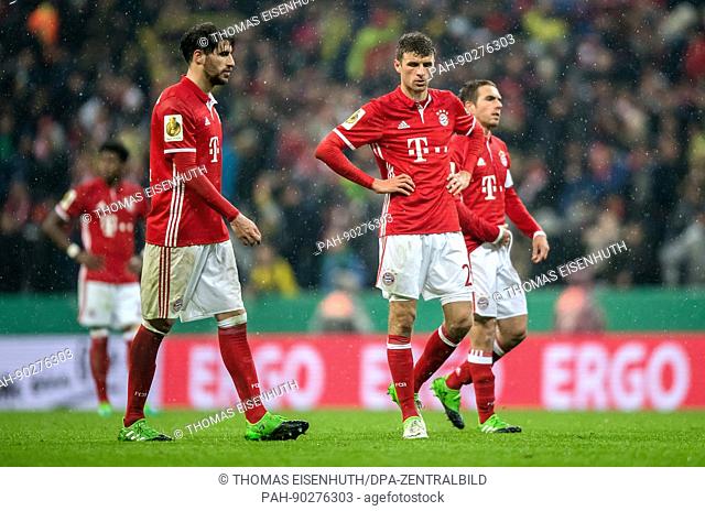 Munich's Javi Martinez (l), Thomas Mueller (c) and Philipp Lahm react after the DFB German Cup semi-final soccer match between Bayern Munich and Borussia...