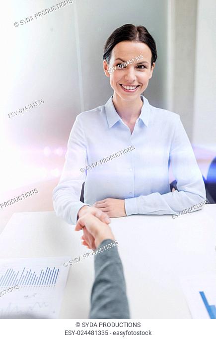 business and office concept - smiling businesswoman shaking hand in office