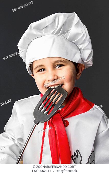 Cooking, Little boy preparing healthy food on kitchen over grey background, cook hat