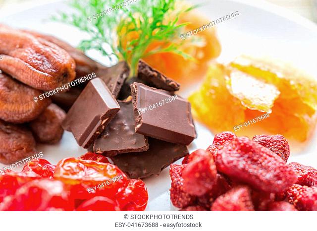 Mixed dried fruits with chocolate in round shape, dried tomatoes, pineapple preserves, strawberries, preserved mango sheet and dried banana, health food concept