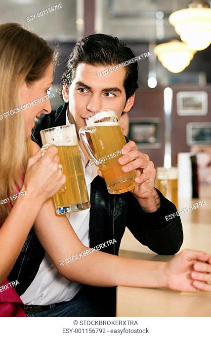 Couple in bar drinking beer flirting