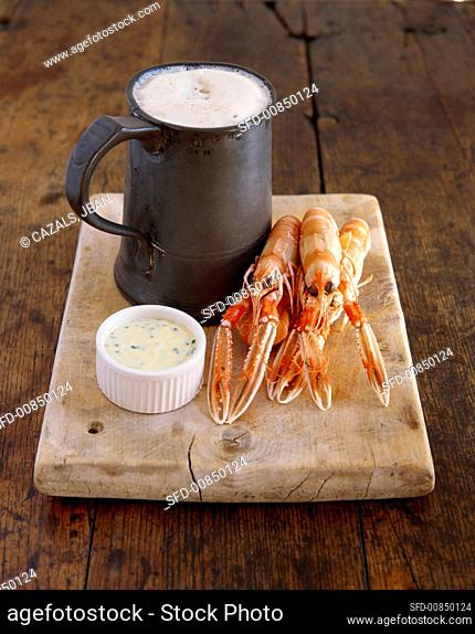 Several cooked freshwater crayfish with herb dip and beer