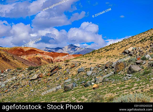 View of unrealy beautiful multicolored clay cliffs Kyzyl Chin and Kuray range on background, Altai mountains, Russia