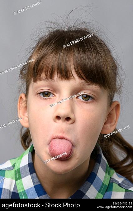Portrait of a ten-year-old girl who shows offended language, European appearance, close-up